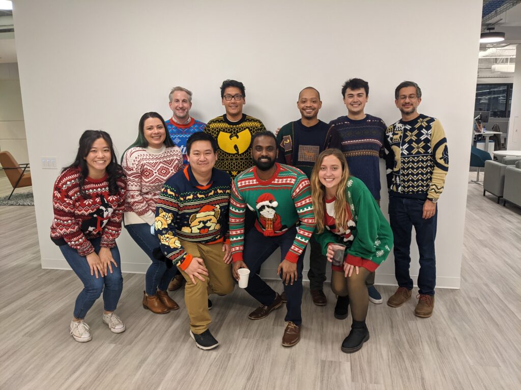 A photo of Pareto employees all dressed with Christmas and holiday-themed sweaters